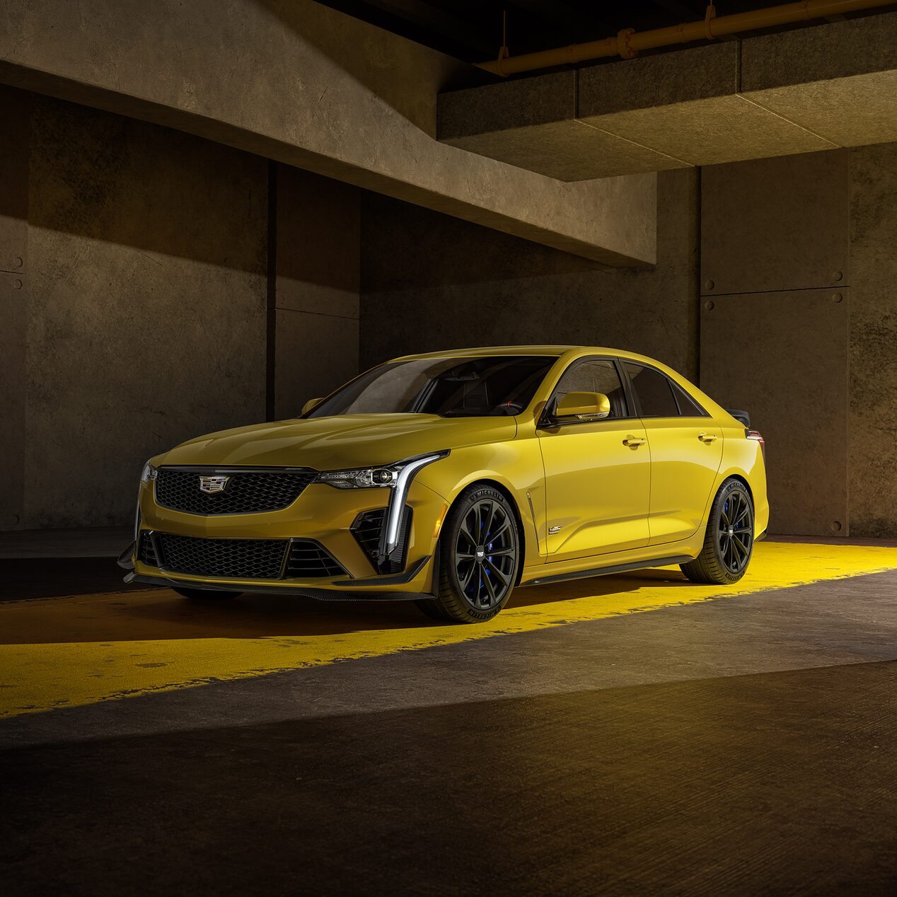 The Cadillac CT4-V Blackwing Sitting in a Parking Garage with Yellow Light Illuminating from the Vehicle