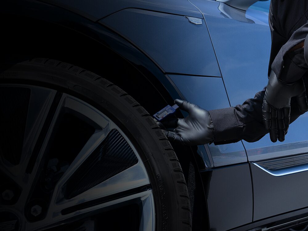 A Cadillac Certified Service Technician Measuring the Tire Tread on a Vehicle