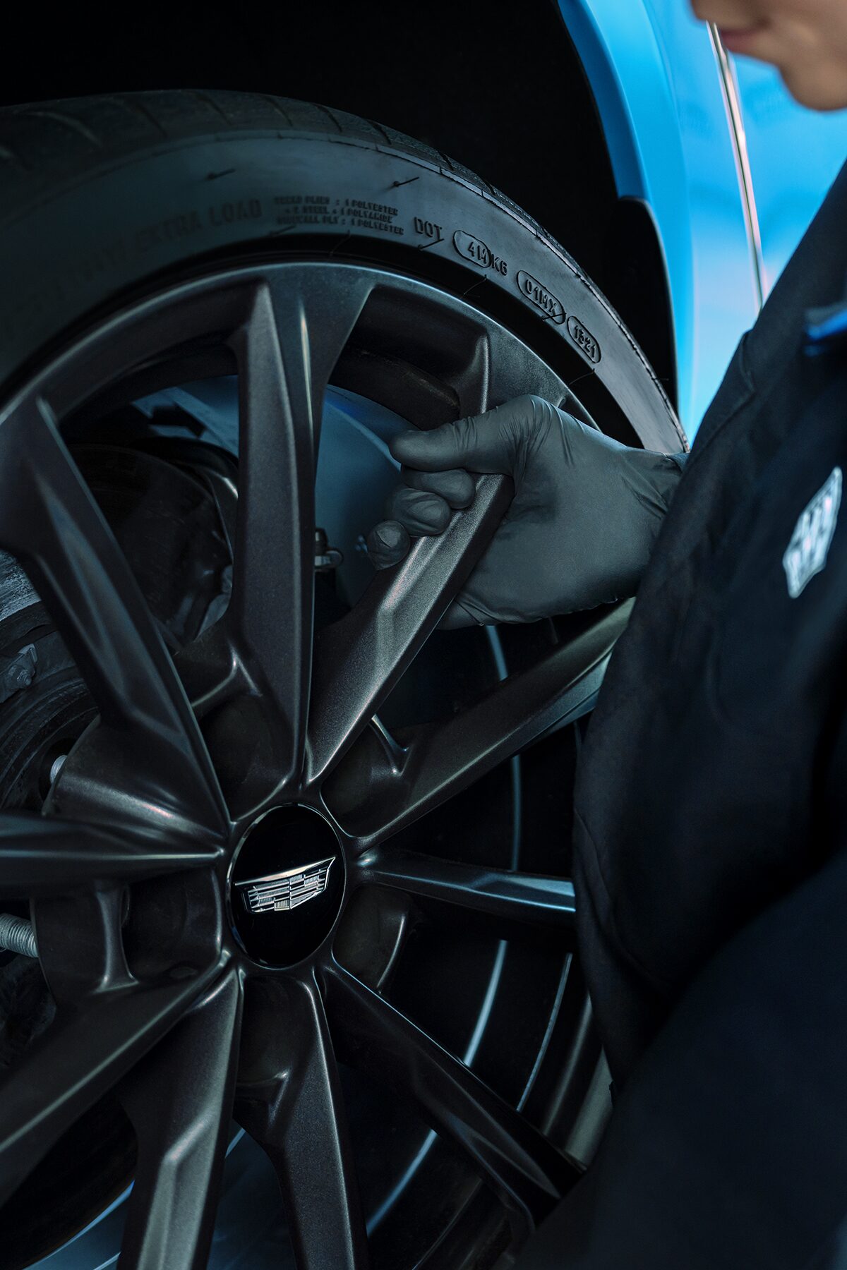 Cadillac Certified Service Technician Installing a New Wheel on a Vehicle