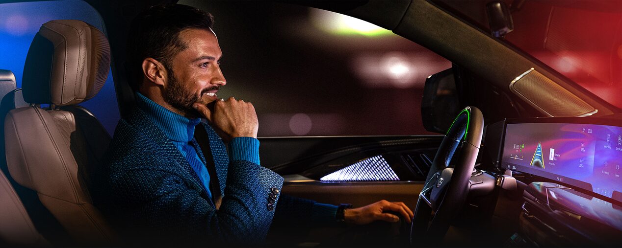 Passenger View of a Woman Using Super Cruise Hands-free Driving Technology in Her Cadillac