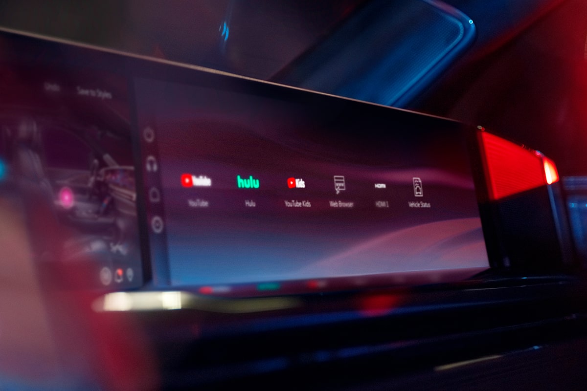 Back Seat View of a Lady Driving a Cadillac and the Passenger Utilizing the InVehicle Apps on the Display Screen