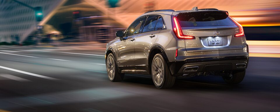 Rear View of the 2025 Cadillac XT4 Driving Fast Through the City at Night