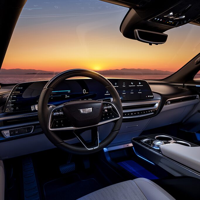 A View of the Sunset Seen from the Drivers Seat of a Cadillac Vehicle