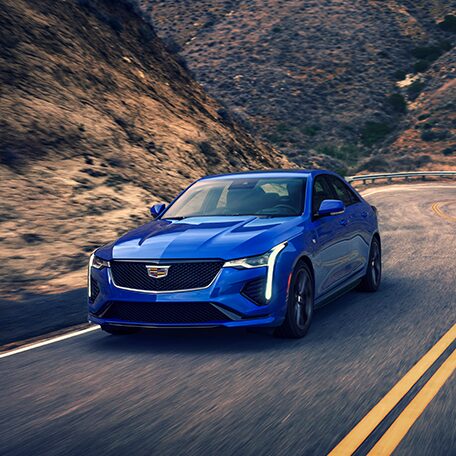 Front View of a Blue CT4 Driving Through a Curvy Mountain Road