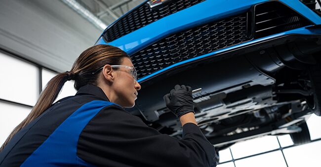 Cadillac Technician Inspecting the Underside of a Vehicle