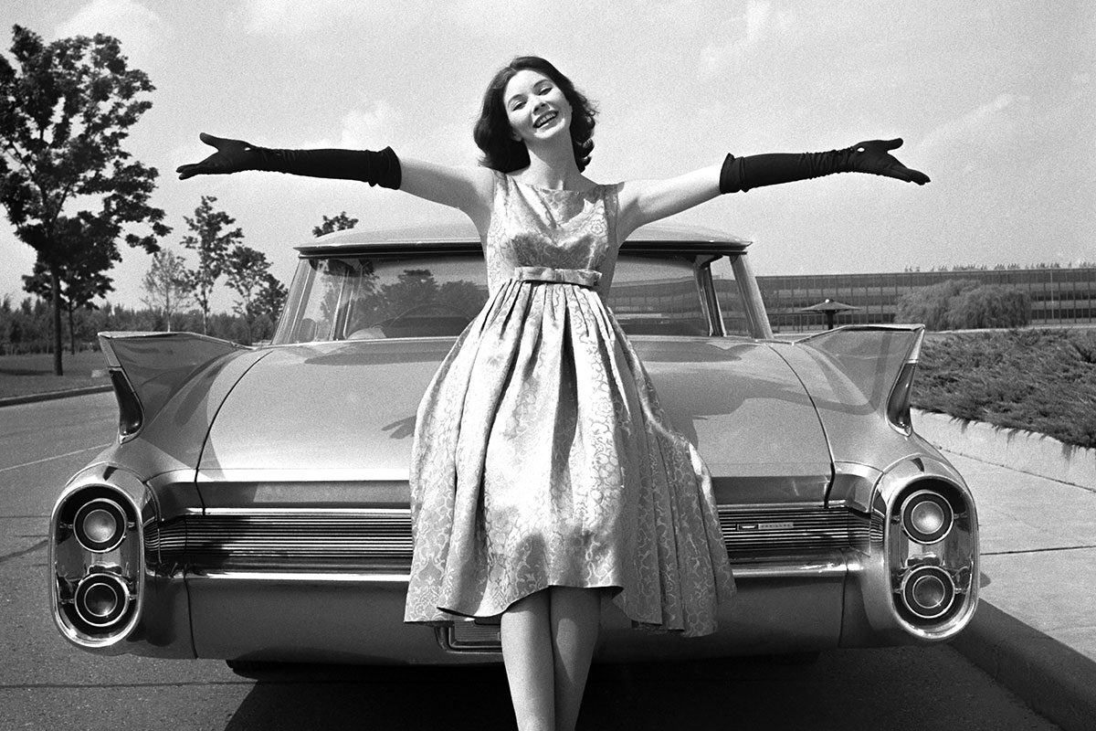 Woman Leaning On Rear Trunk Of The Cadillac Coupe de Ville