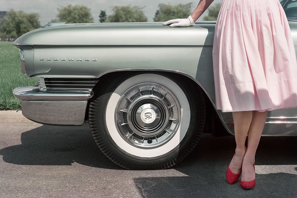 Woman Posing Next To Cadillac Eldorado Badging