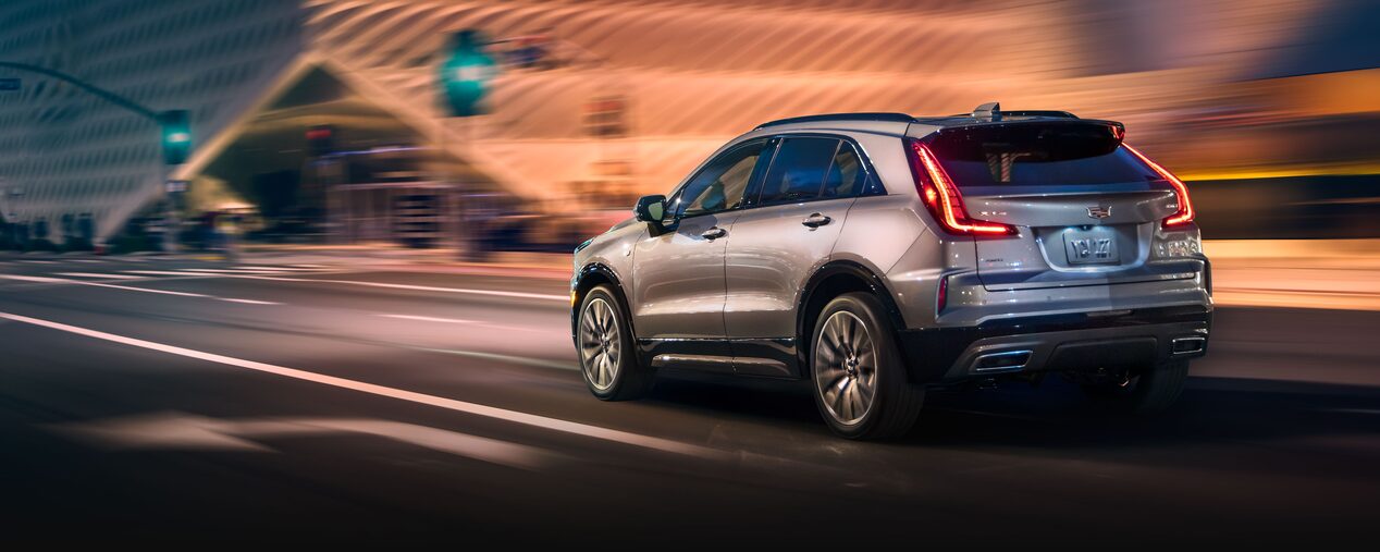 Rear View of the 2025 Cadillac XT4 Driving Fast Through the City at Night