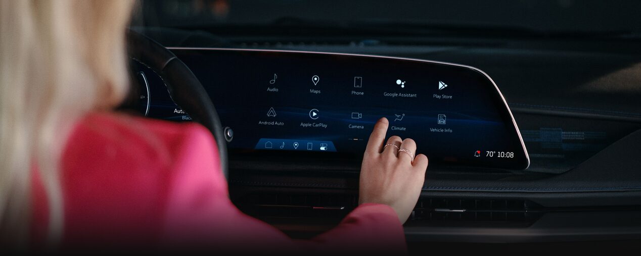 A Woman Utilizing the 2025 Cadillac XT5 Infotainment System Touch Screen
