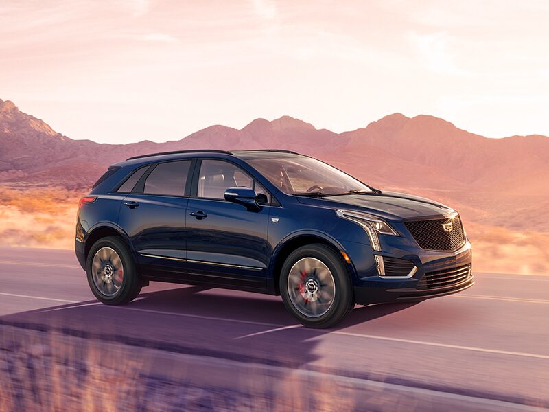 The 2025 Cadillac XT5 Driving Through a Western Landscape During Golden Hour