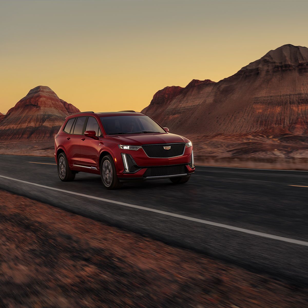 The Infrared Tricoat Cadillac XT6 Speeding Down a Desert Road By Canyons