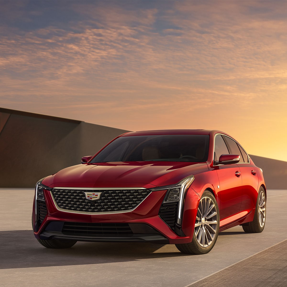 Front Driver's Side View of Parked Red 2025 Cadillac CT5 With Beautiful Sun Setting Displayed