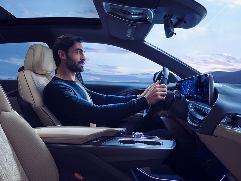 Passenger Seat View of a Man Driving the 2025 Cadillac LYRIQ Using the Navigation System