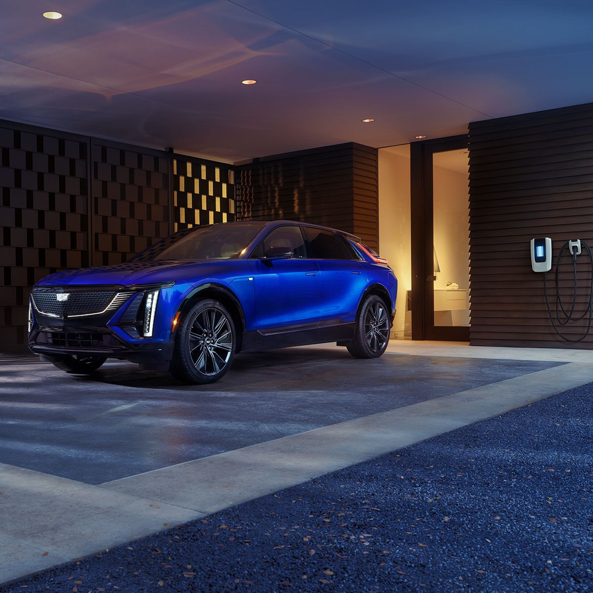 The Side Profile of a Blue 2025 Cadillac LYRIQ Charging and Parked in a Luxurious Garage
