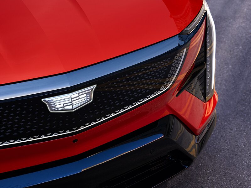 Close-up View of a Red 2025 Cadillac OPTIQ's Grille and Headlamp