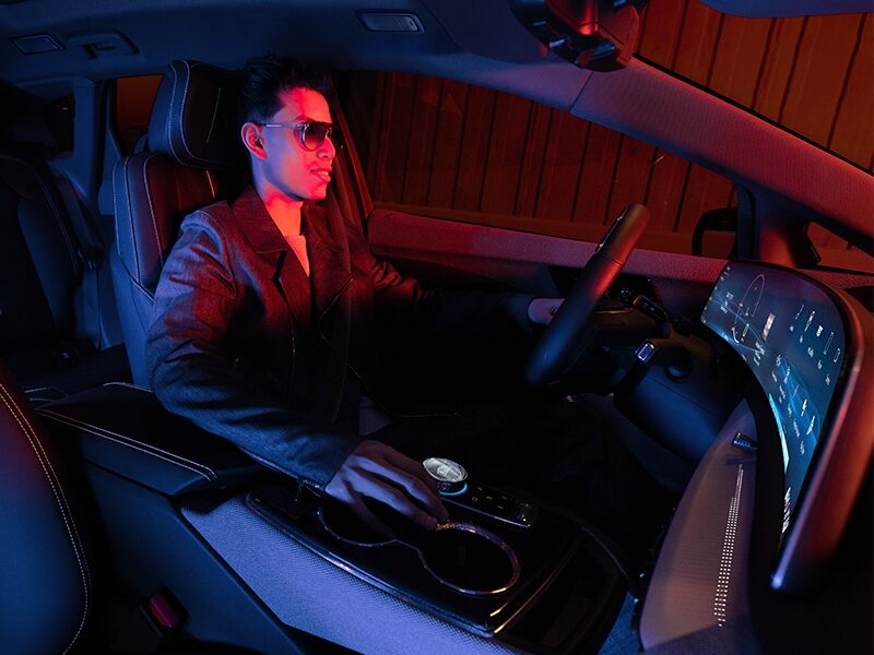 Passenger View of a Man Driving the 2025 Cadillac OPTIQ in a Red Light