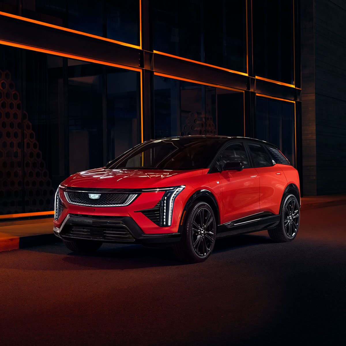 Three Quarter View of a Red 2025 Cadillac OPTIQ Parked on Dark Street