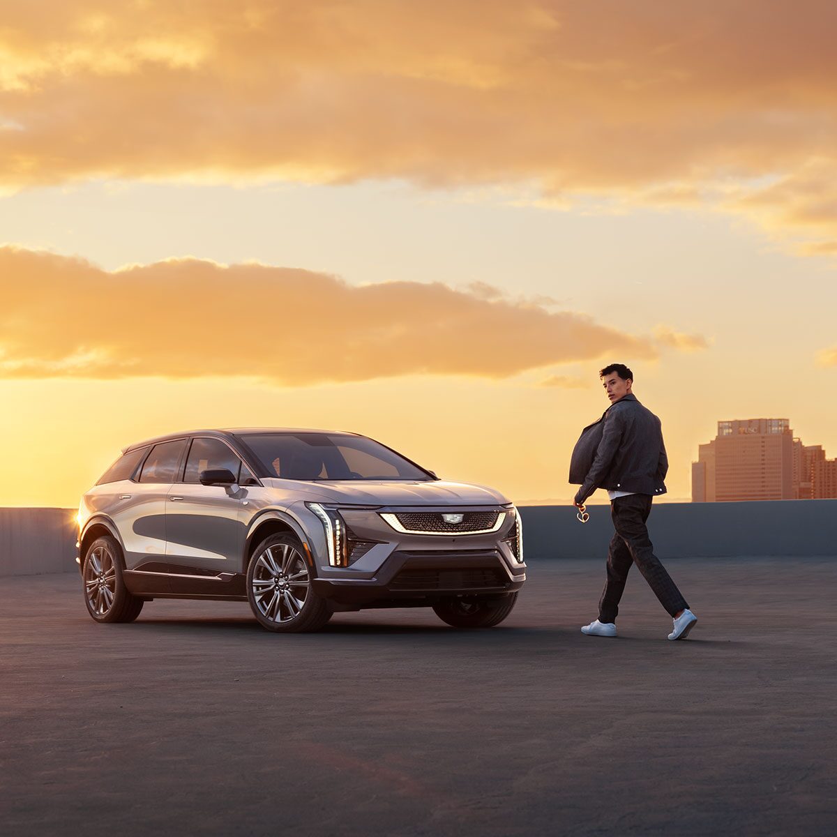 A Man Walking To a 2025 Cadillac OPTIQ During a Beautiful Sunset