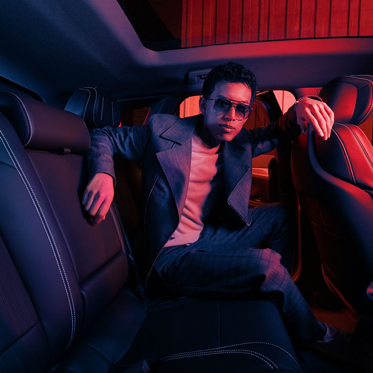 A Fashionably Dressed Man Posing in the Spacious Back Seat of the 2025 Cadillac OPTIQ