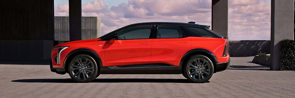 A Side Profile View of a Red 2025 Cadillac OPTIQ Parked