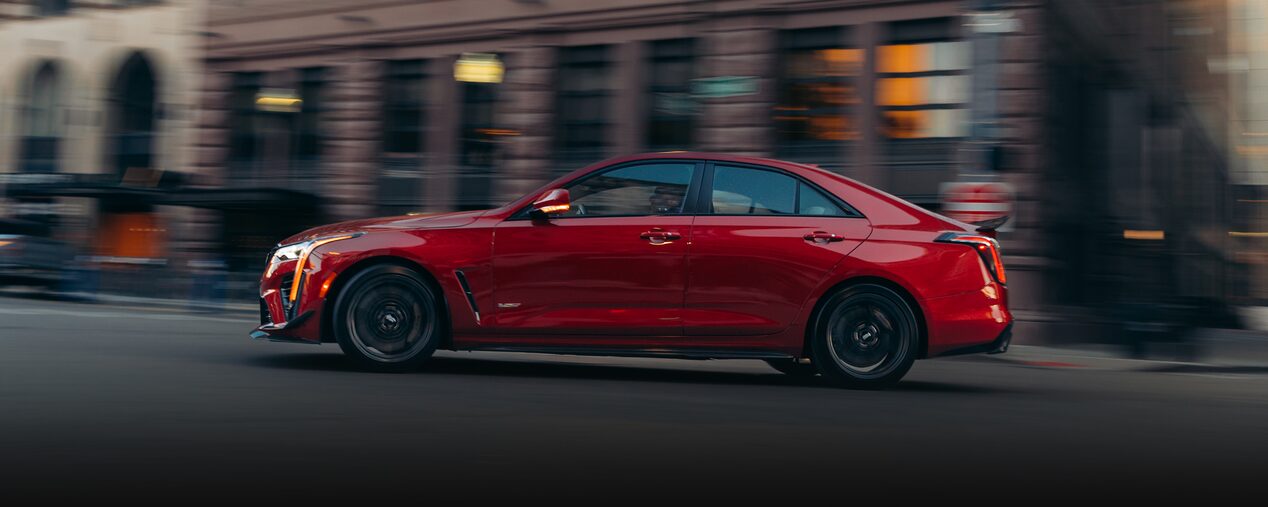 The Side Profile of a Red 2025 CT4-V Speeding Past Downtown