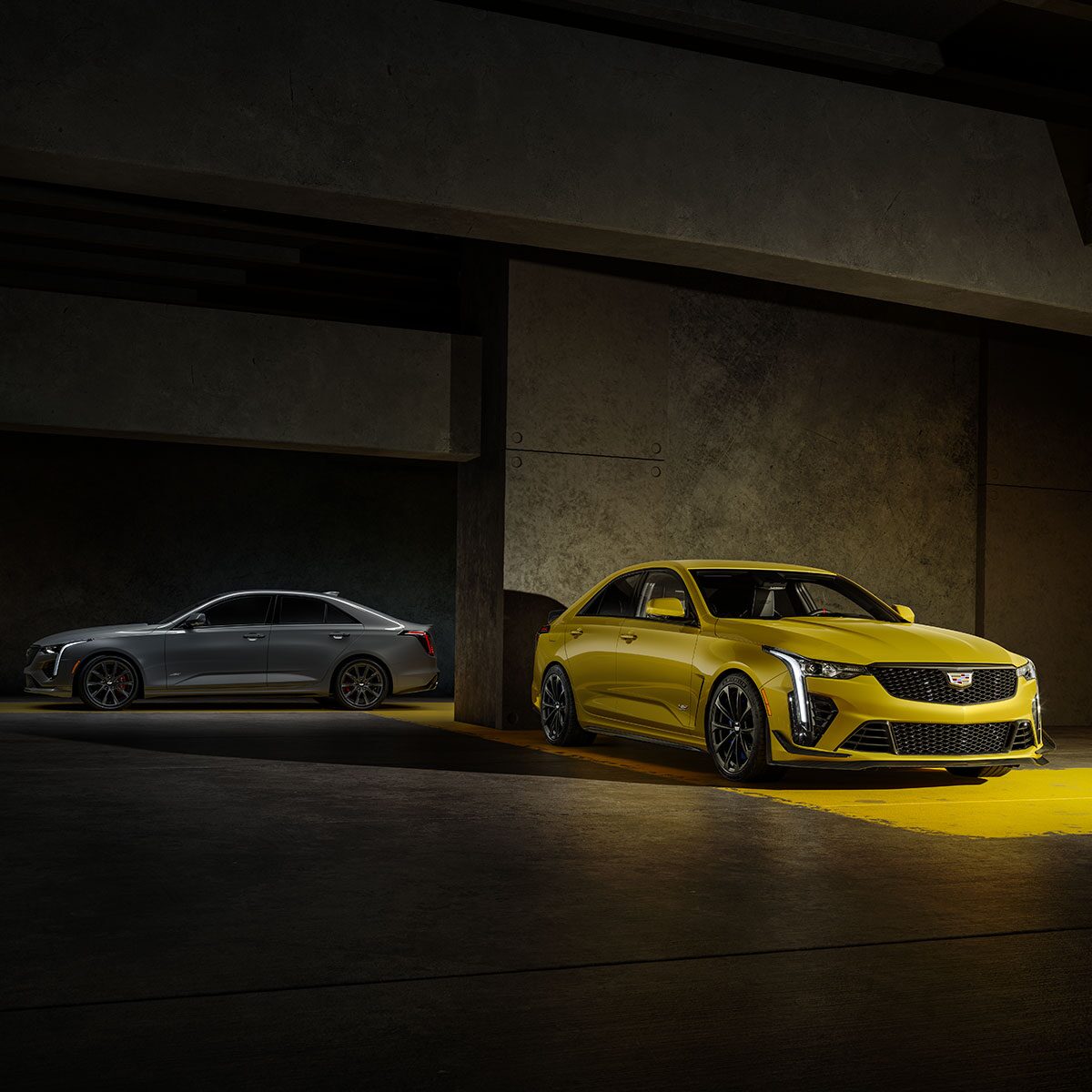 A Silver 2025 CT4-V and a Yellow 2025 CT4-V Blackwing Parked in a Parking Garage