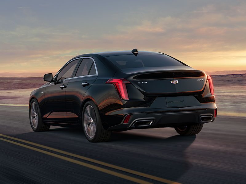 Three Quarters Rear View of a Black 2025 CT4 Driving Down a Desert Road