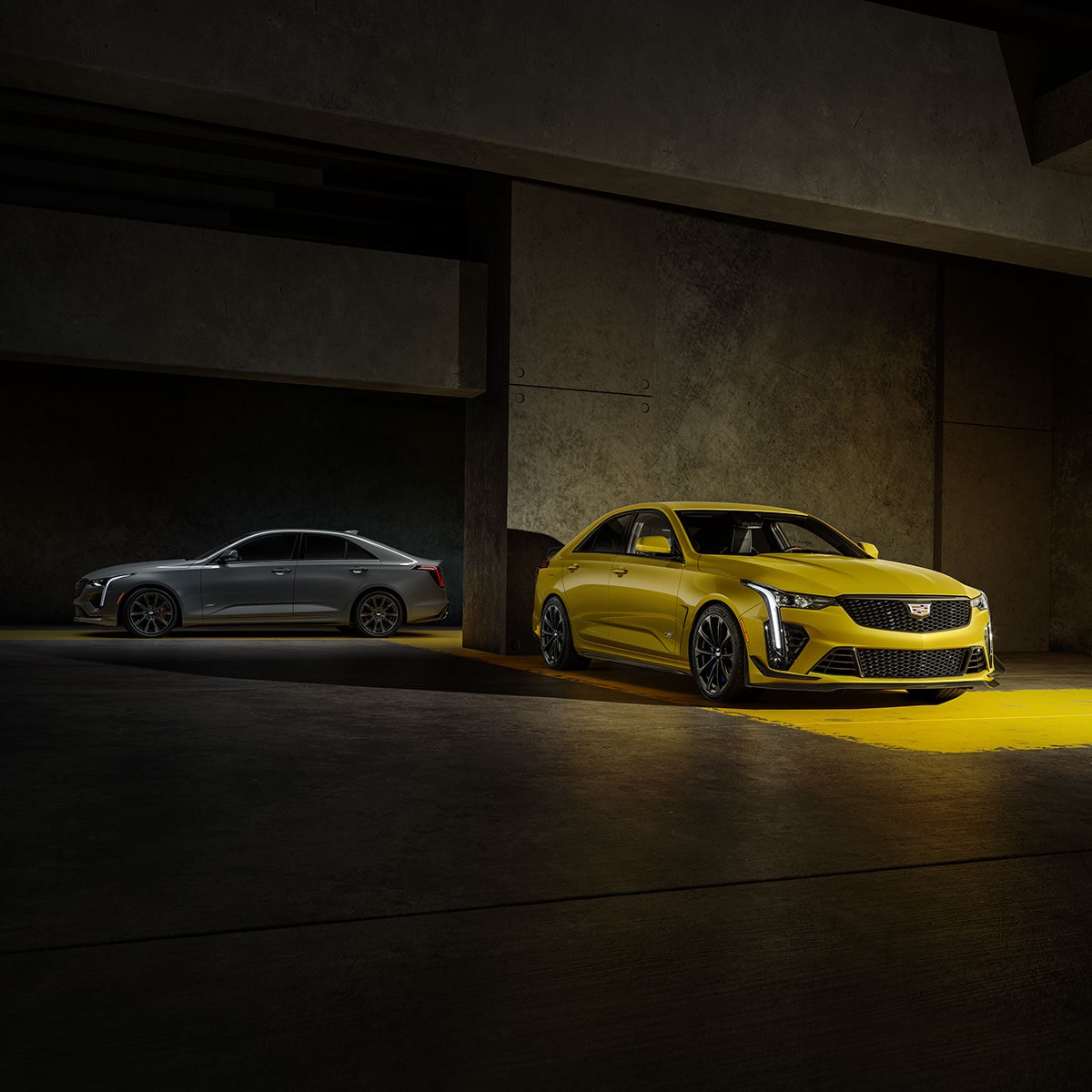 A Silver 2025 CT4-V and a Yellow 2025 CT4-V Blackwing Parked in a Parking Garage
