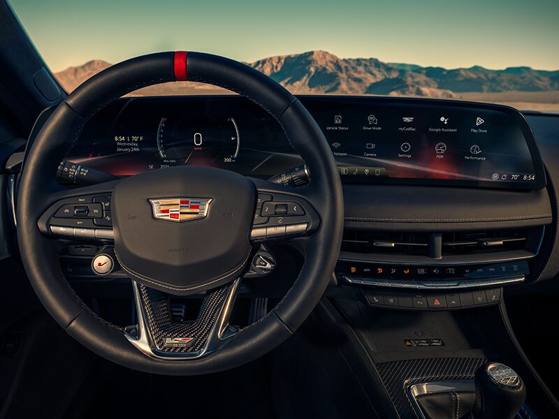 Driver's Seat View of a 2025 Cadillac CT5-V Steering Wheel and Dashboard in Front of Mountains