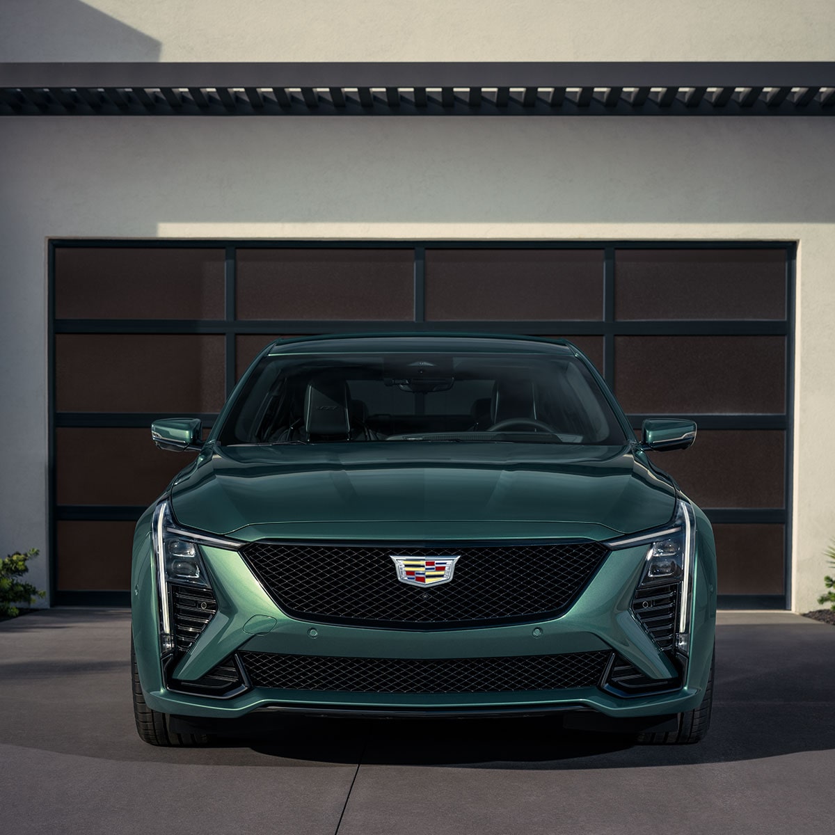 Front View of a Green 2025 Cadillac CT5-V in Front of a Closed Garage