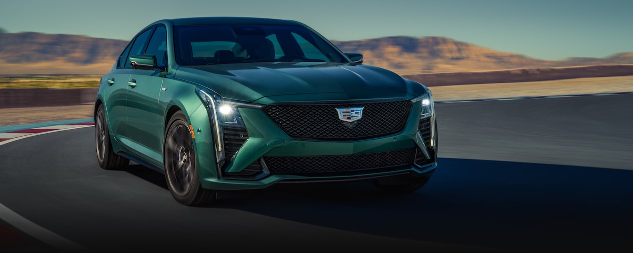 Three-Quarter View of a Green 2025 Cadillac CT5-V Driving Down the Road on Surrounded by Desert