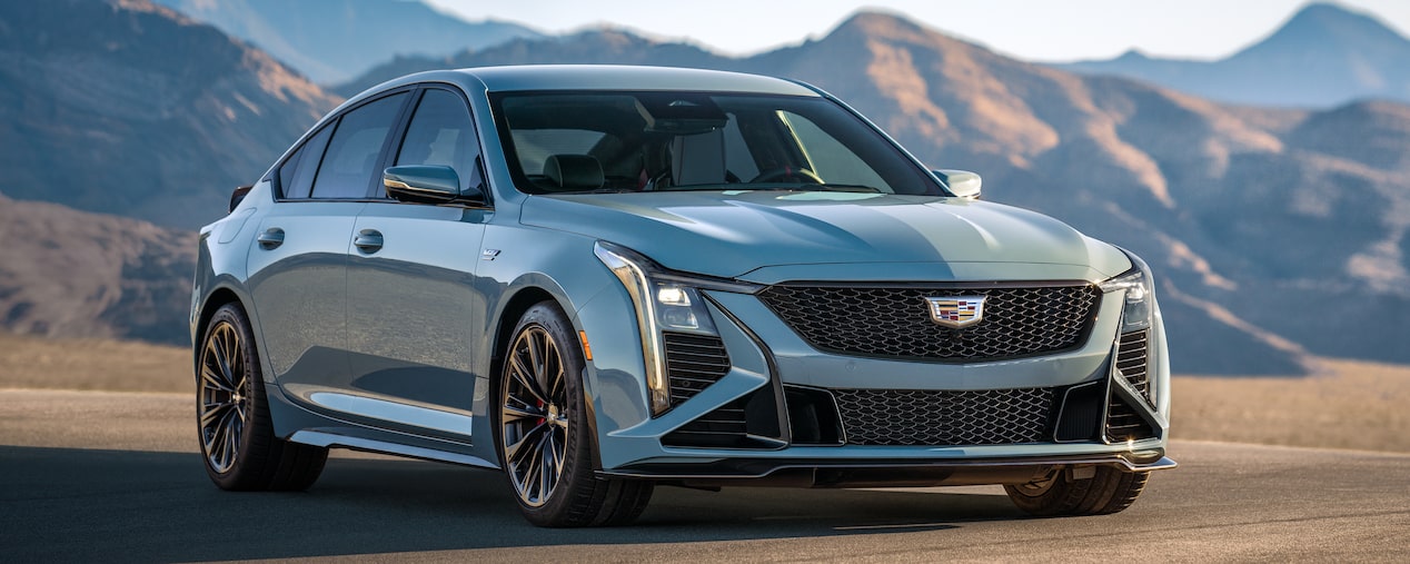 Three-Quarters View of a Light Blue 2025 Cadillac CT5-V in a Desert with Mountains Visible in the Distance