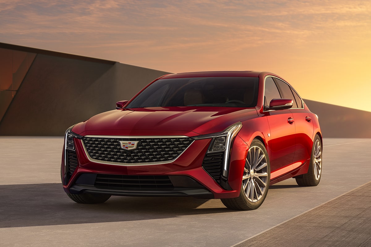 Front Driver's Side View of Parked Red 2025 Cadillac CT5 With Beautiful Sun Setting Displayed