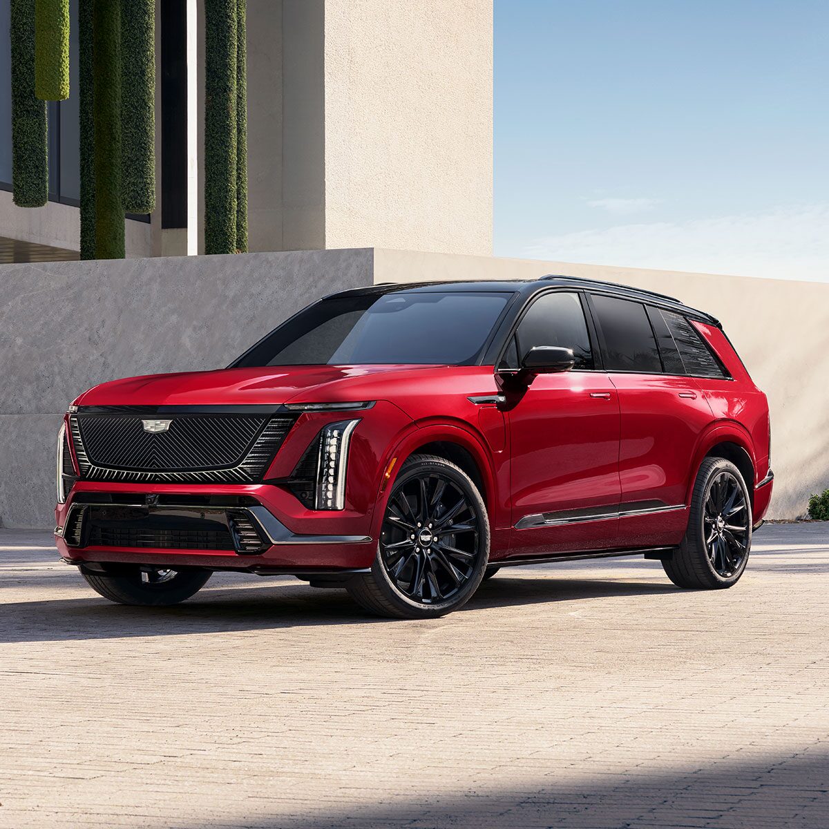 Three-quarters View of a Red 2026 VISTIQ Electric SUV Parked Near a Concrete Wall