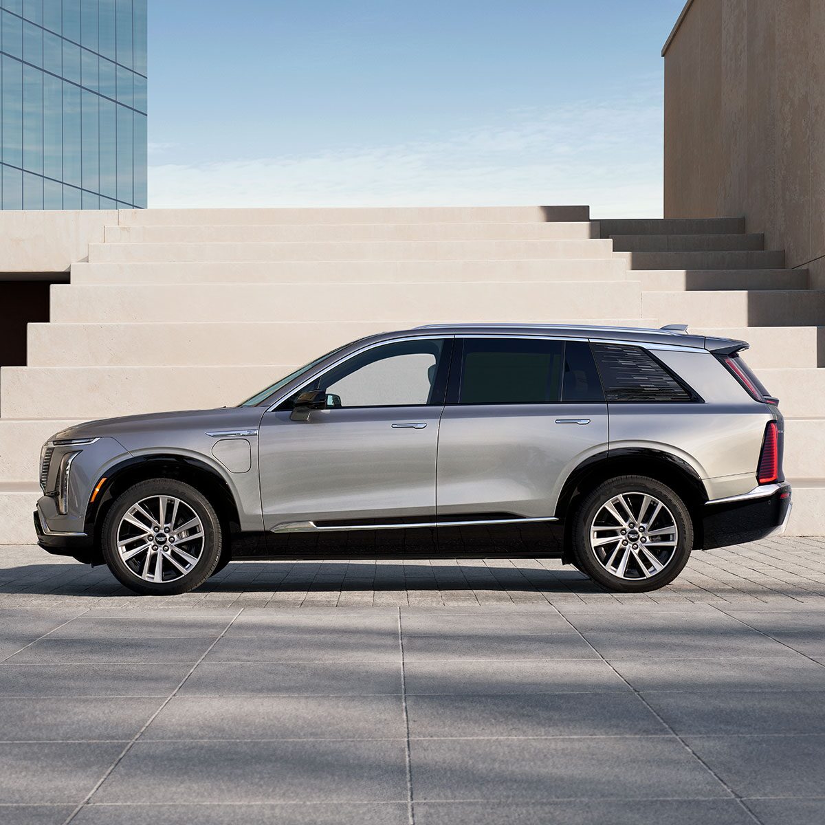 Profile View of a 2026 VISTIQ 7-seater Electric SUV Parked Below Concrete Steps