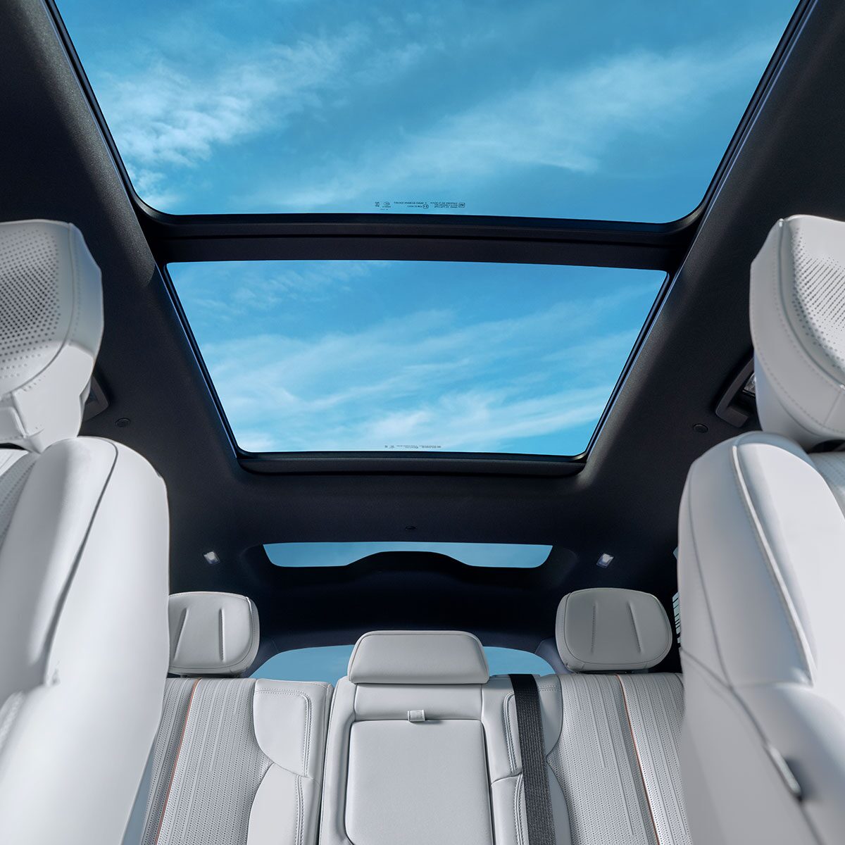 Low Interior View of the 2026 VISTIQ Second and Third Row Seating and the Sunroof Fully Open Outlooking a Beautiful Blue Sky