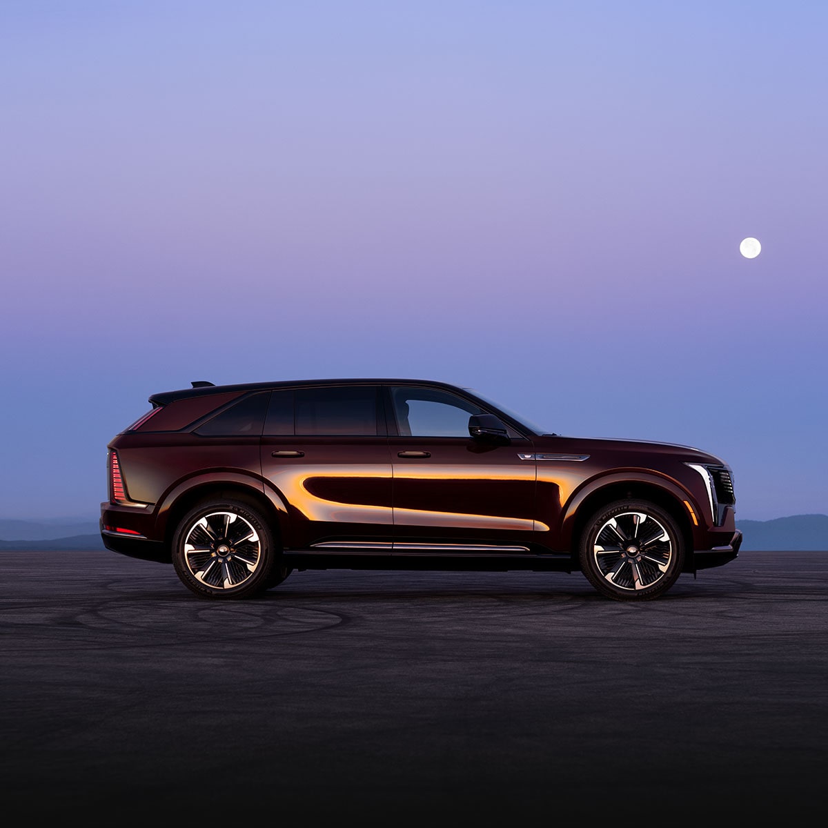 The Side Profile of the 2026 ESCALADE IQ Parked Under a Beautiful Moon in the Desert