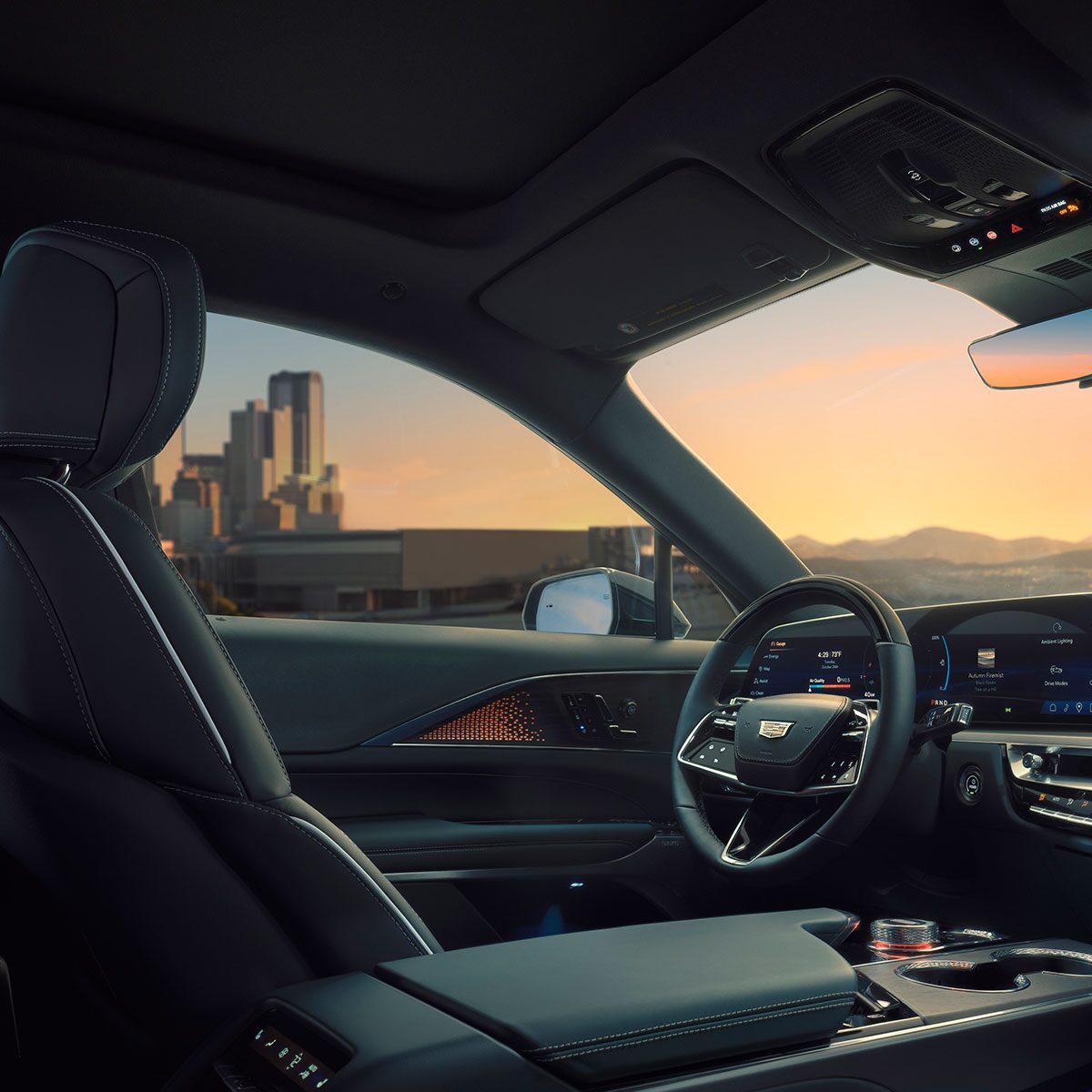 Passenger View of the Driver's Side of the 2025 Cadillac LYRIQ Overlooking a City During a Sunset