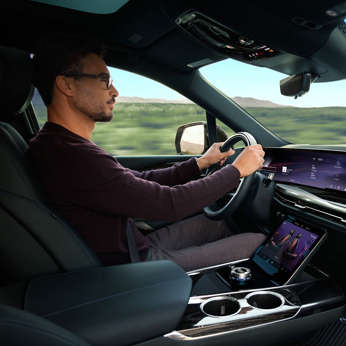 Passenger View of a Man Driving the 2026 ESCALADE IQL Large Electric SUV in the Desert