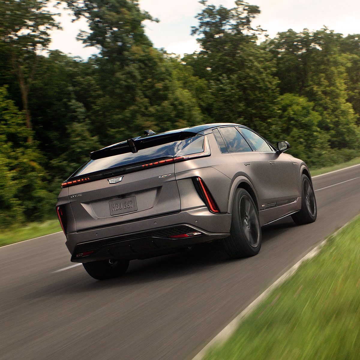 Rear View of a Cadillac LYRIQ-V Performance EV Driving Down a Road