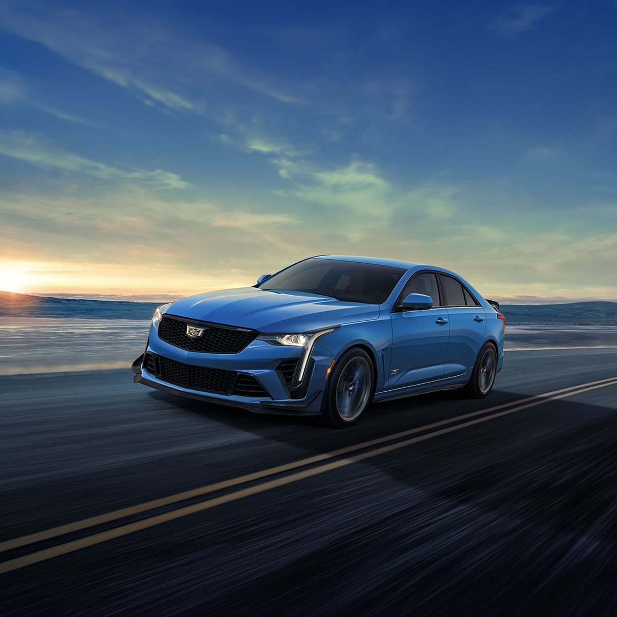 Three-quarters Front View of a Blue CT4-V Driving Down the Road