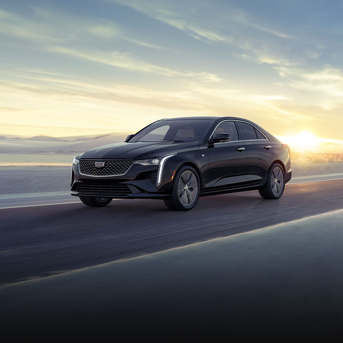 Three-quarters View of a 2026 CT4 Driving Through The Desert During a Sunrise