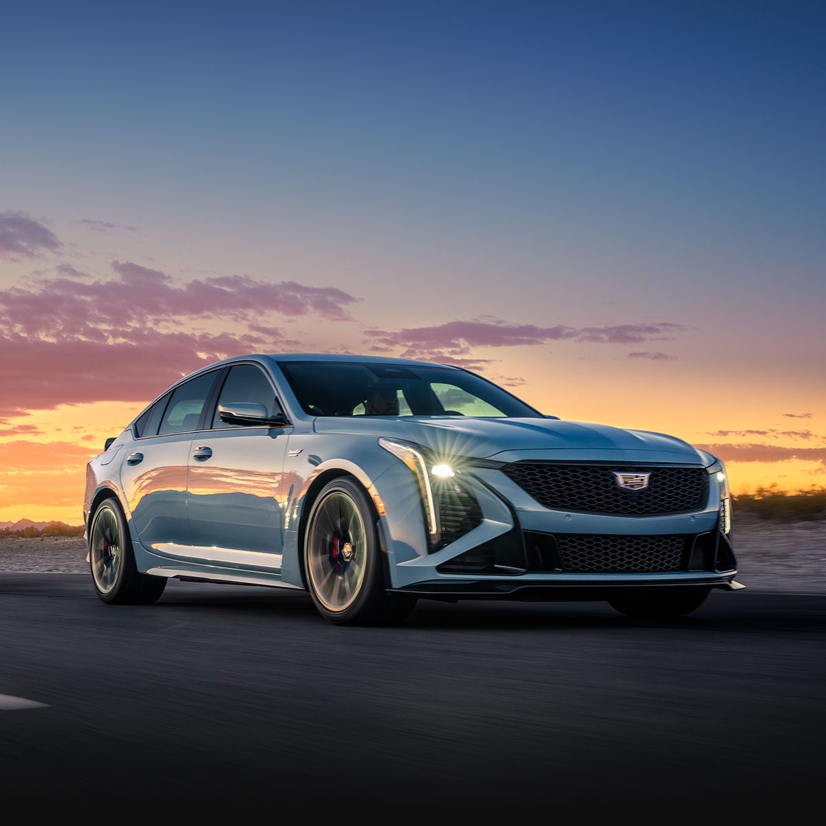 Three-Quarter View of a Green  Cadillac CT5-V Driving Down the Road on Surrounded by Desert