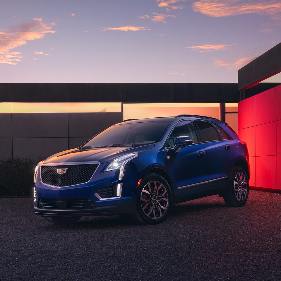 The Beautiful 2026 Cadillac XT5 Parked at Dusk in Front of Modern House With Lights On