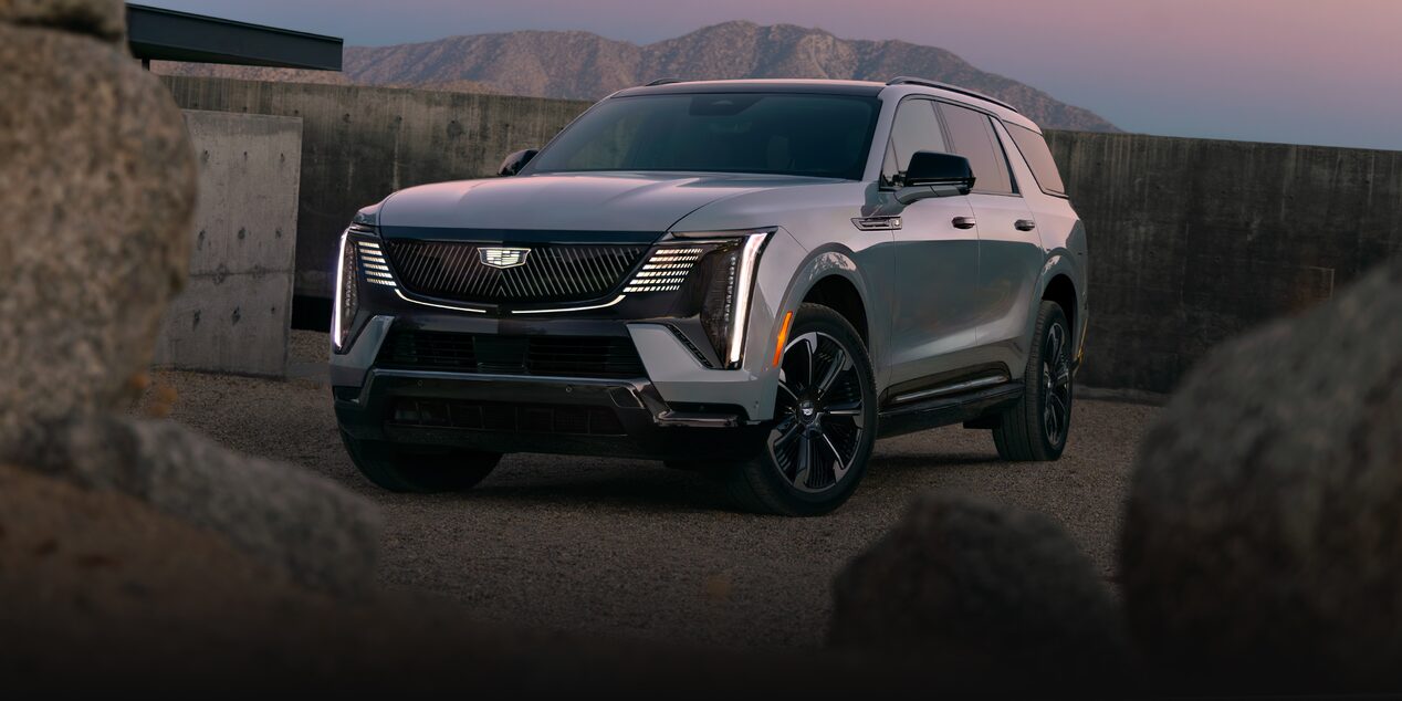Front Three-Quarter View of the 2026 ESCALADE IQL Parked near a Concrete Wall During Dusk